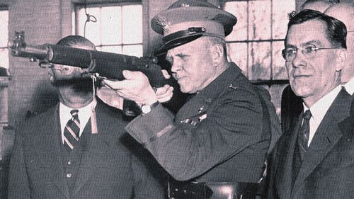 Maj. Gen. Charles Wesson checks the sights on the first M1 Garand