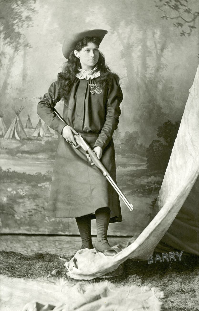Annie Oakley proudly poses with her Winchester Model 1892